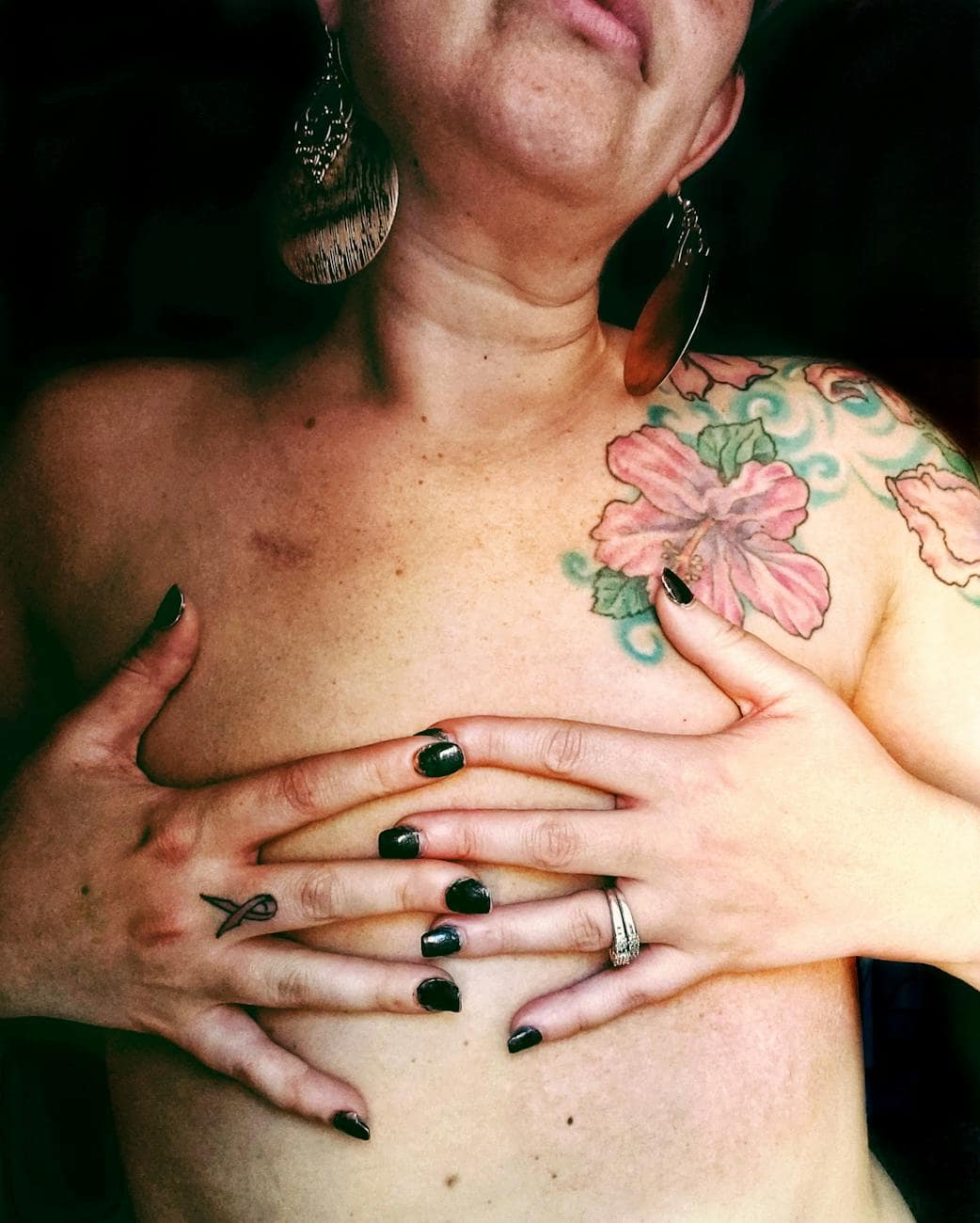 a topless woman covering her chest