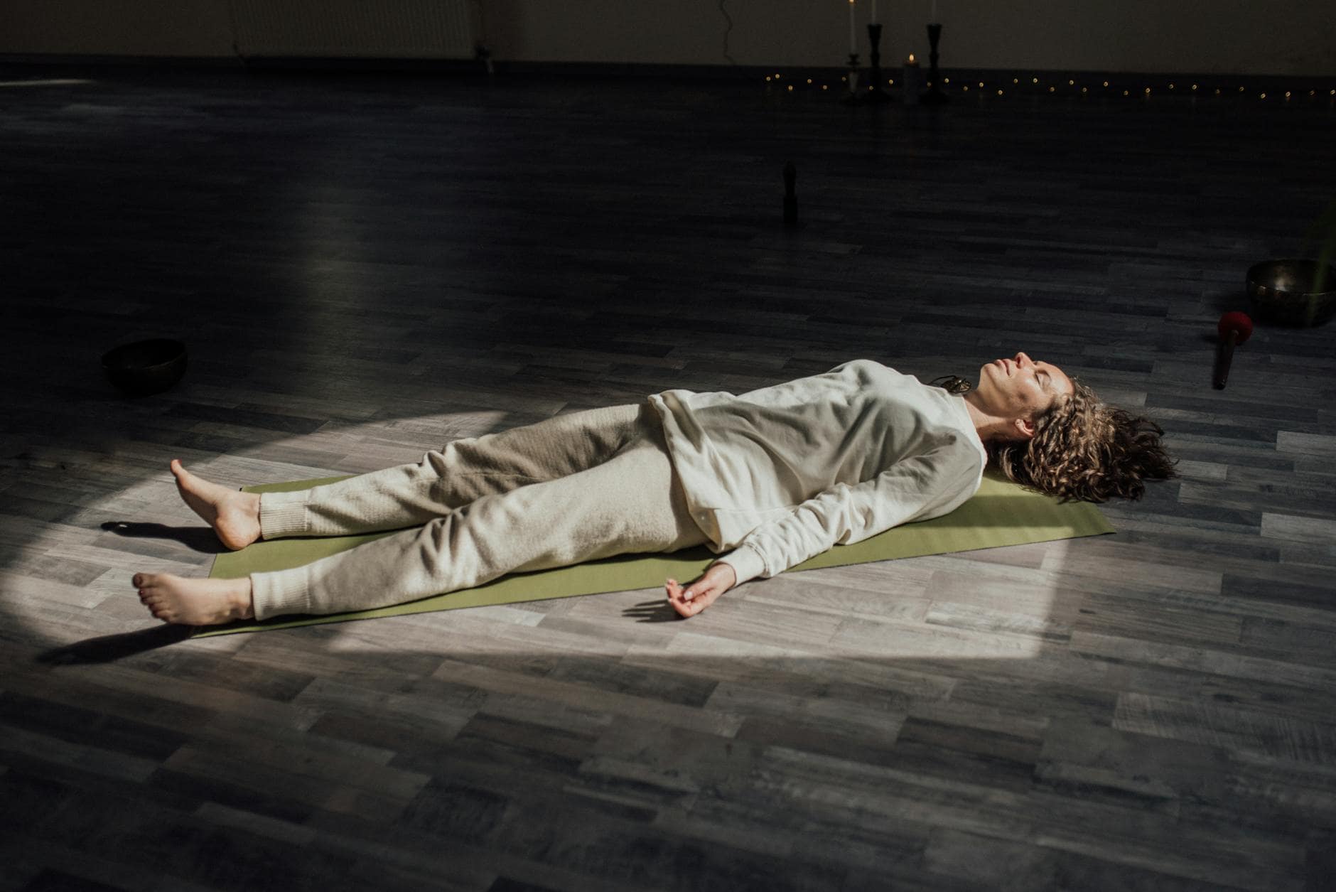 woman lying down on floor relaxing and meditating