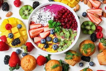 assorted sliced fruits in white ceramic bowl