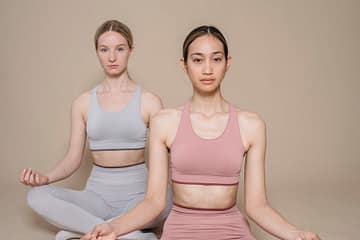 women in activewear meditating