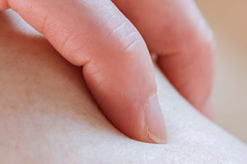 unrecognizable person touching leg in room