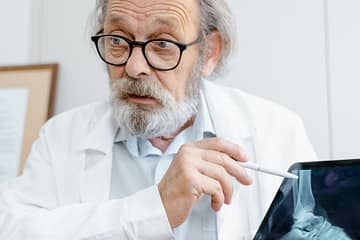 a doctor holding a digital tablet while explaining
