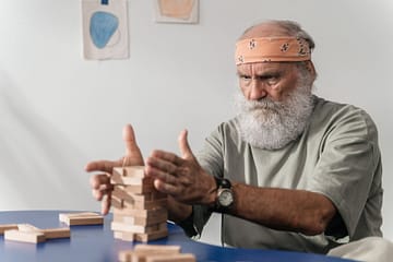 man in gray t shirt wearing building jenga blocks