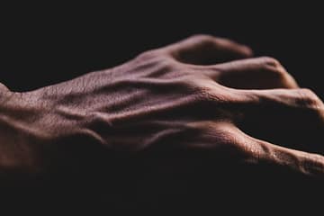 close up of a veined adult hand in shadow