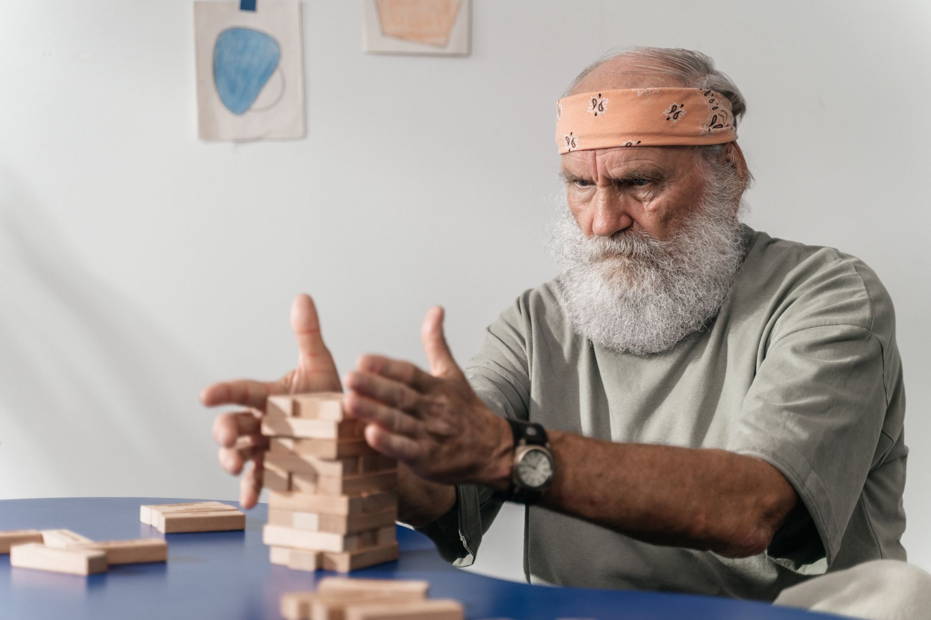 man in gray t shirt wearing building jenga blocks