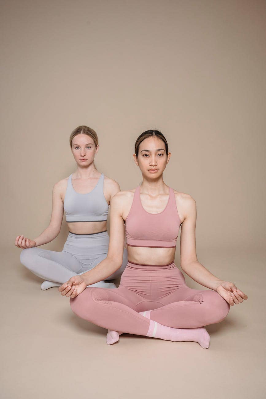 women in activewear meditating